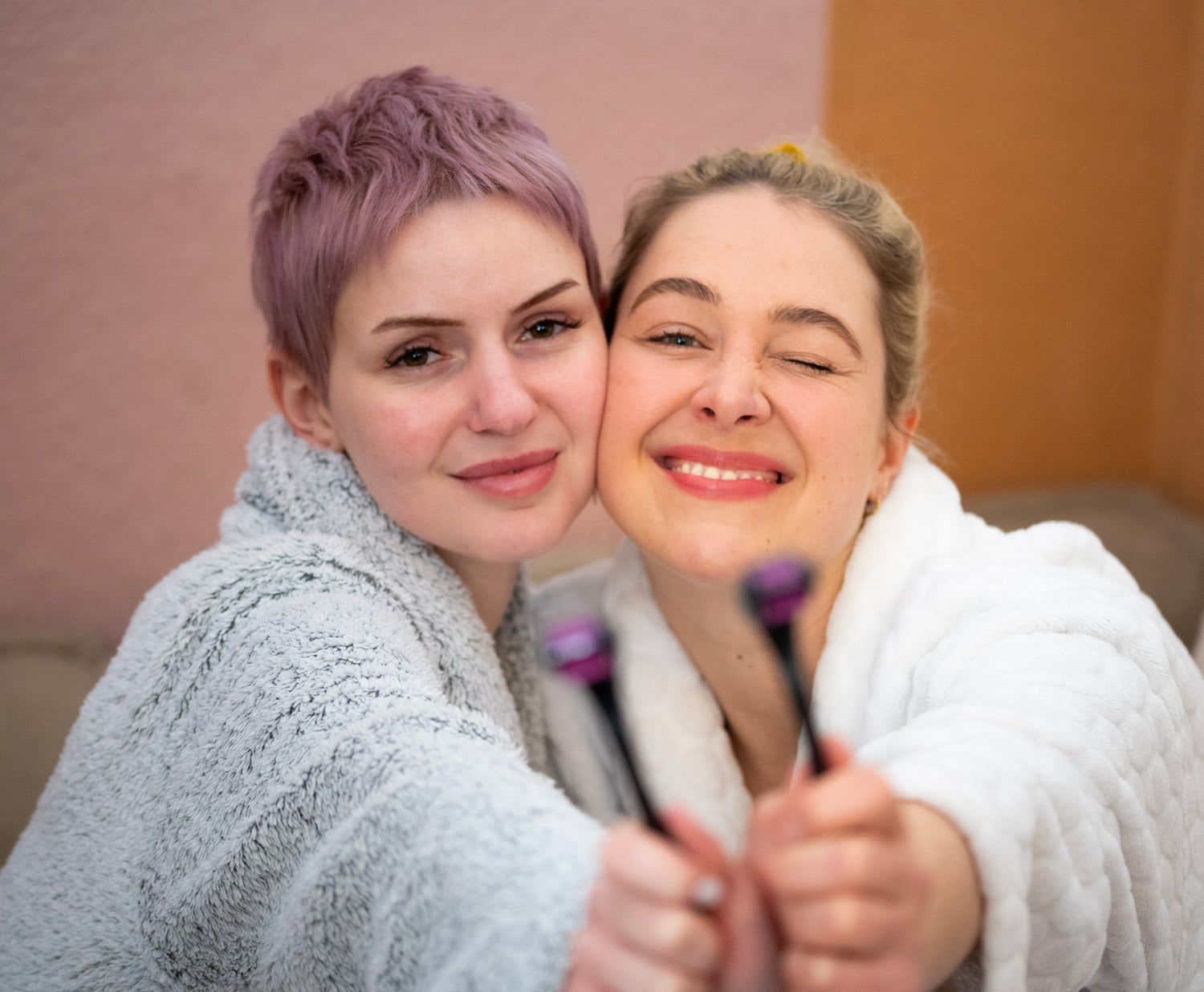 Maria und Luna die Gründerinnen von Skinglowup halten zwei Dermaroller in die Kamera.