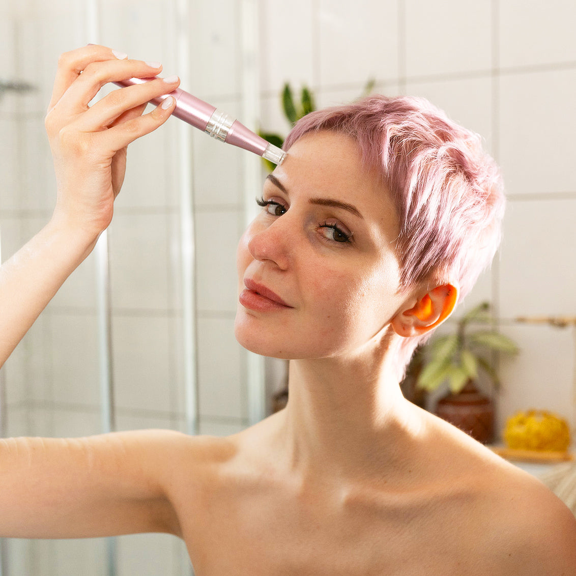 Der Dermapen von Skinglowup während der Microneedling Anwendung zuhause. Der Needling Pen wird auf der Stirn angewendet um Sorgenfalten, große Poren und Falten zu bekämpfen.